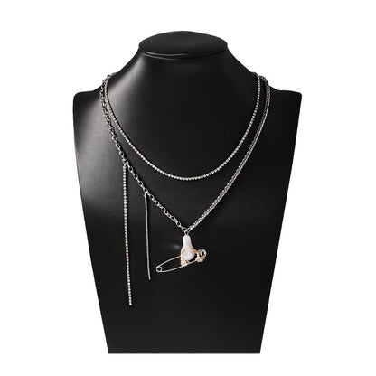 This Unique Pin Pendant Necklace features an elegant asymmetrical chain design adorned with Zirconia and Faux Pearl accents. Perfect for dressing up casual attire or as a thoughtful gift, this creatively designed pendant adds a touch of sophistication to