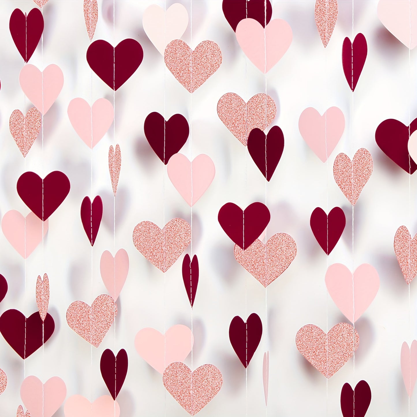 Rose-gold, pink, and burgundy Valentine's decorations featuring paper heart streamers, perfect for engagements, Mother's Day, weddings, anniversaries, bridal showers, birthdays, or Galentine's Day celebrations.