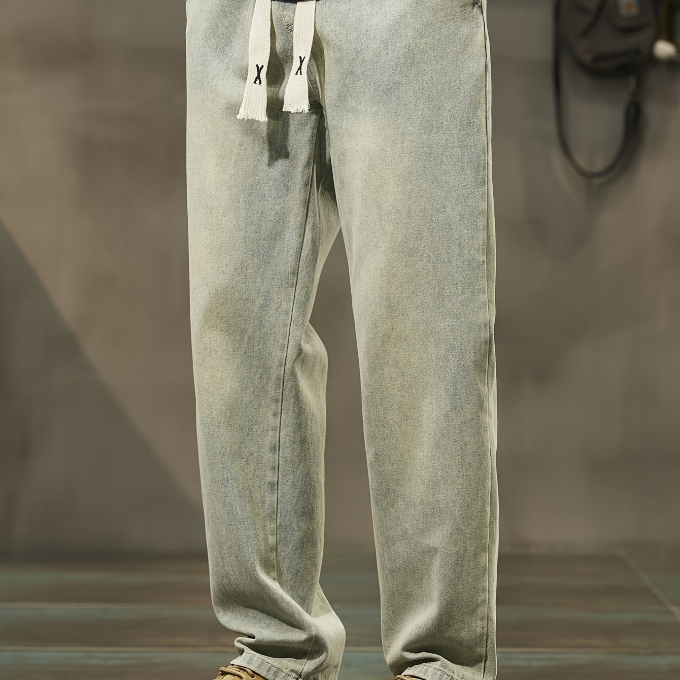 Men's denim pants with pockets, drawstring waist, suitable for outdoor activities.