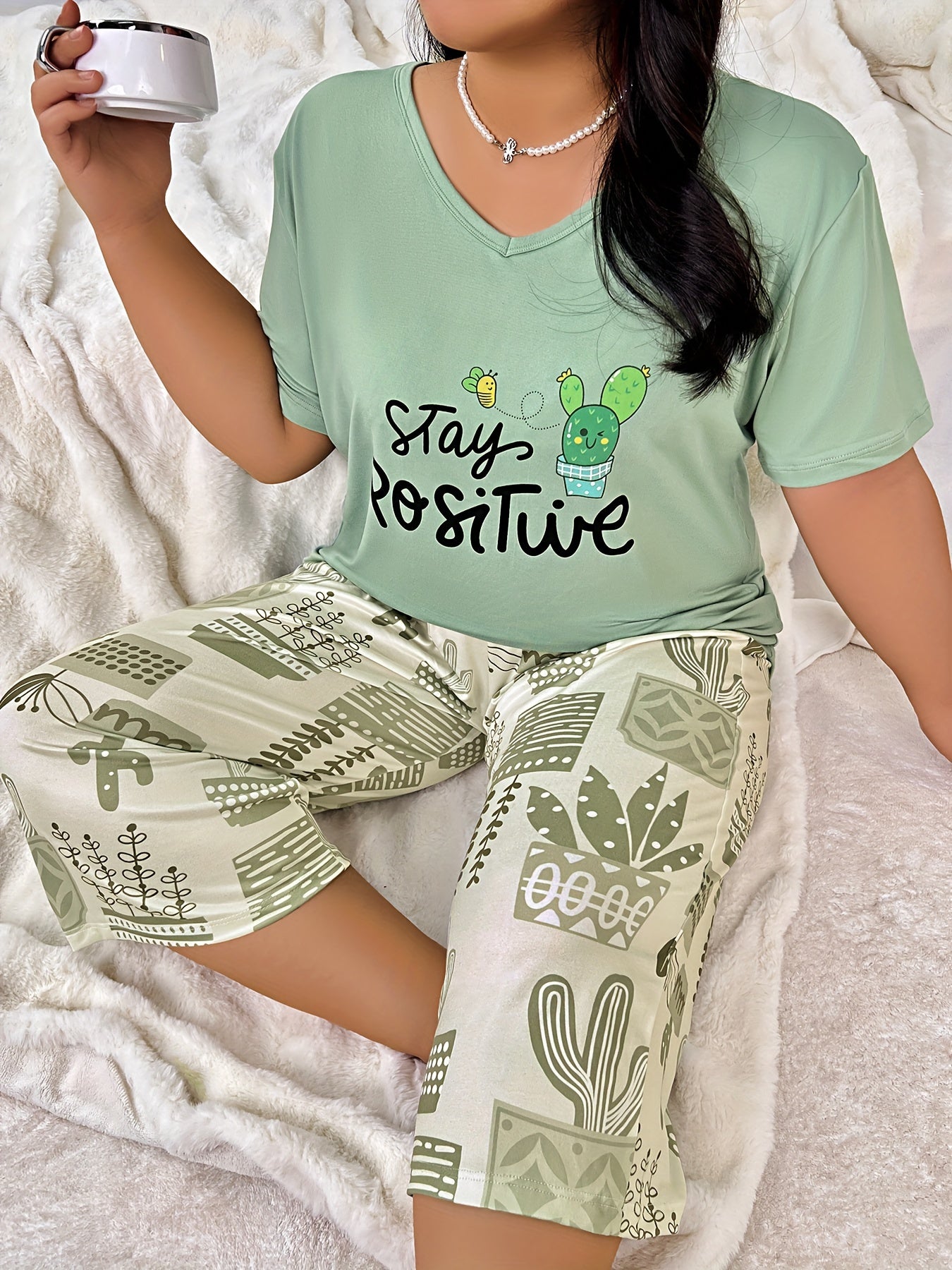 Plus size women's lounge set with cartoon cactus print top and capri pants.