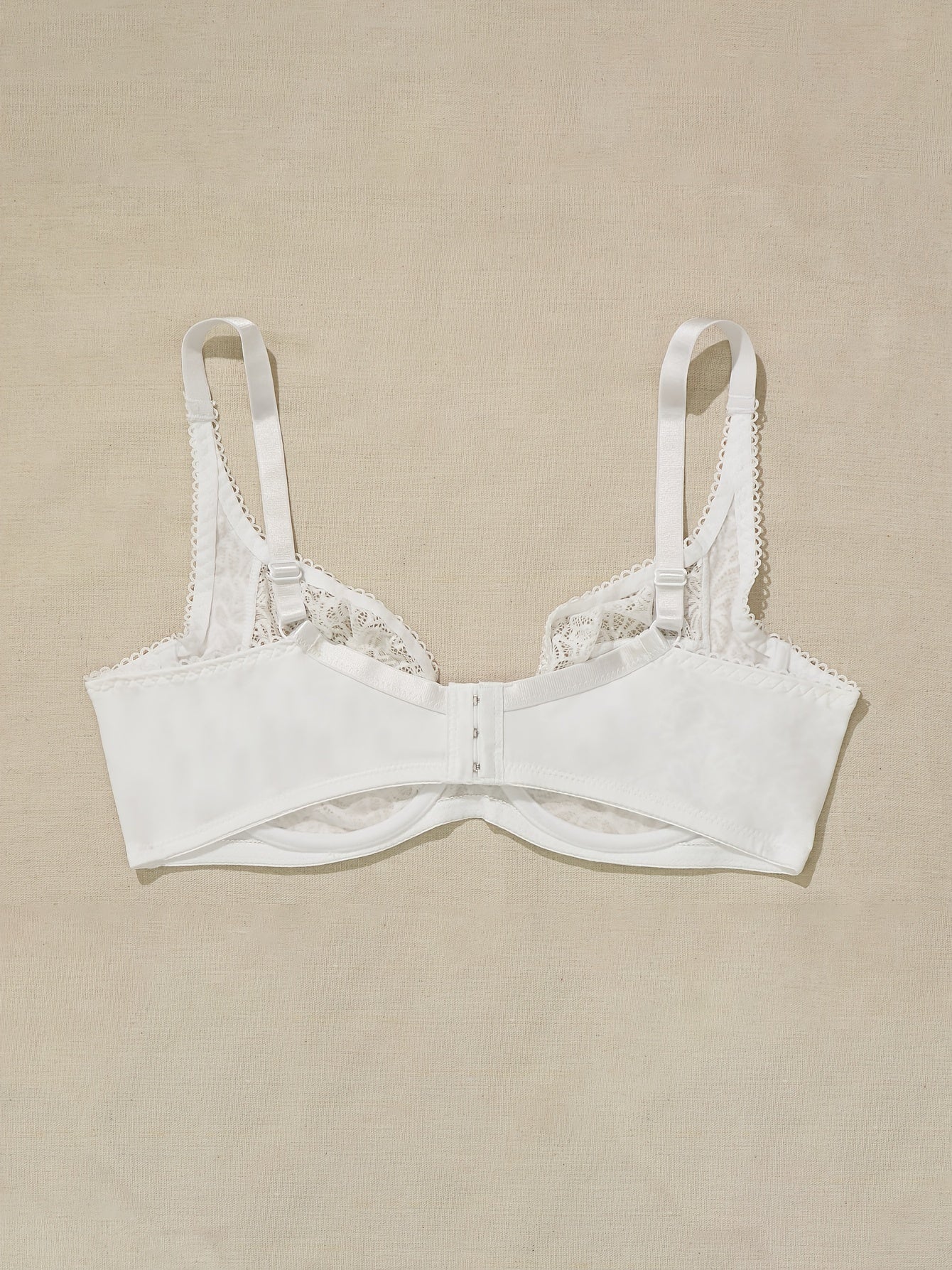 Plus-size white lace bra for women with floral cut-out design, underwire support, and hand washable.