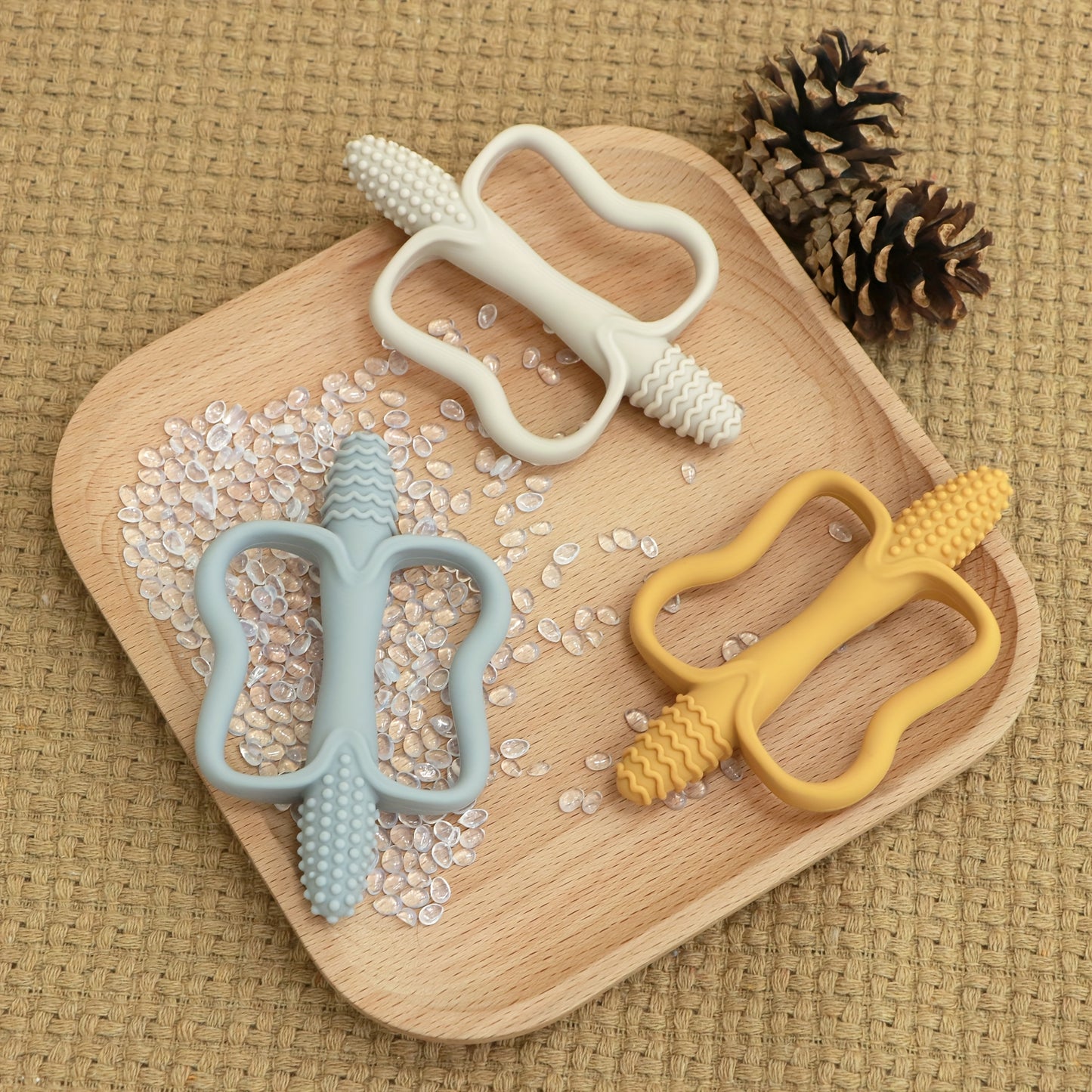 Corn-shaped teething stick with handle, available in 6 colors.