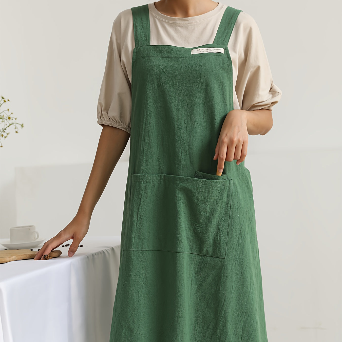 1 linen apron with cross straps and pockets for use in gardening, cooking, baking, painting, barista work, and other tasks.