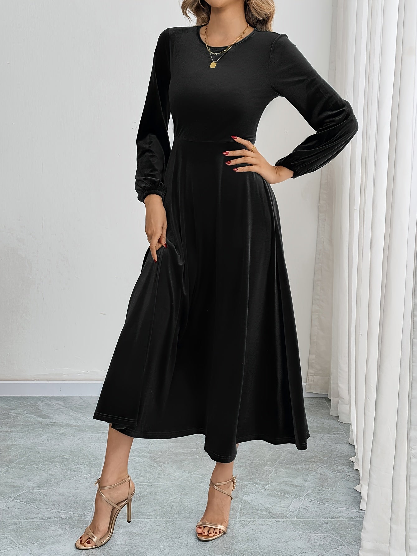 Black velvet A-line dress with flared sleeves, crew neck, and long sleeve made of polyester knit for all-season wear. Ideal for adult women's fashion as elegant attire.