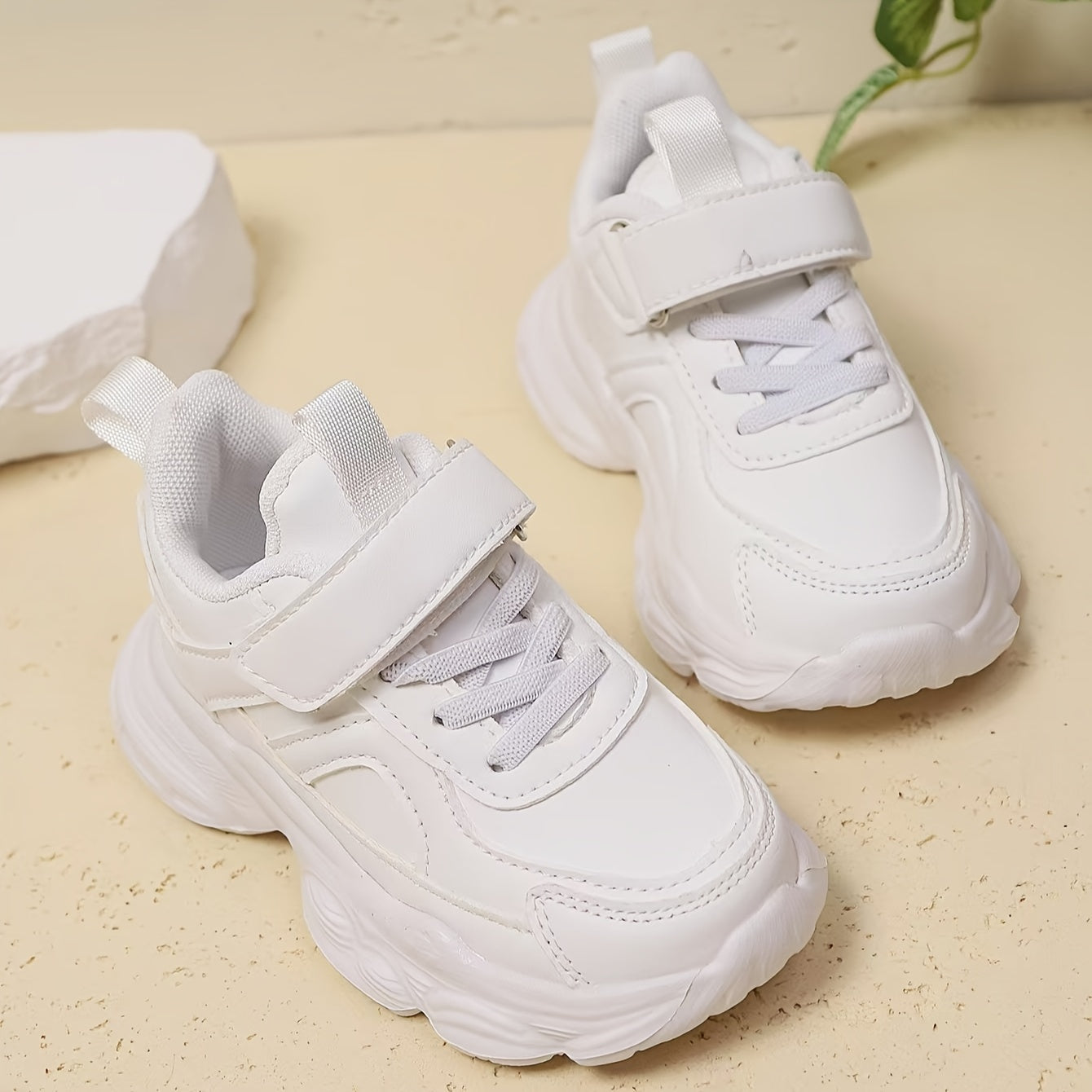 White unisex running sneakers for youngsters with hook-and-loop closure, soft EVA sole, geometric design, ideal for outdoor activities and casual wear.