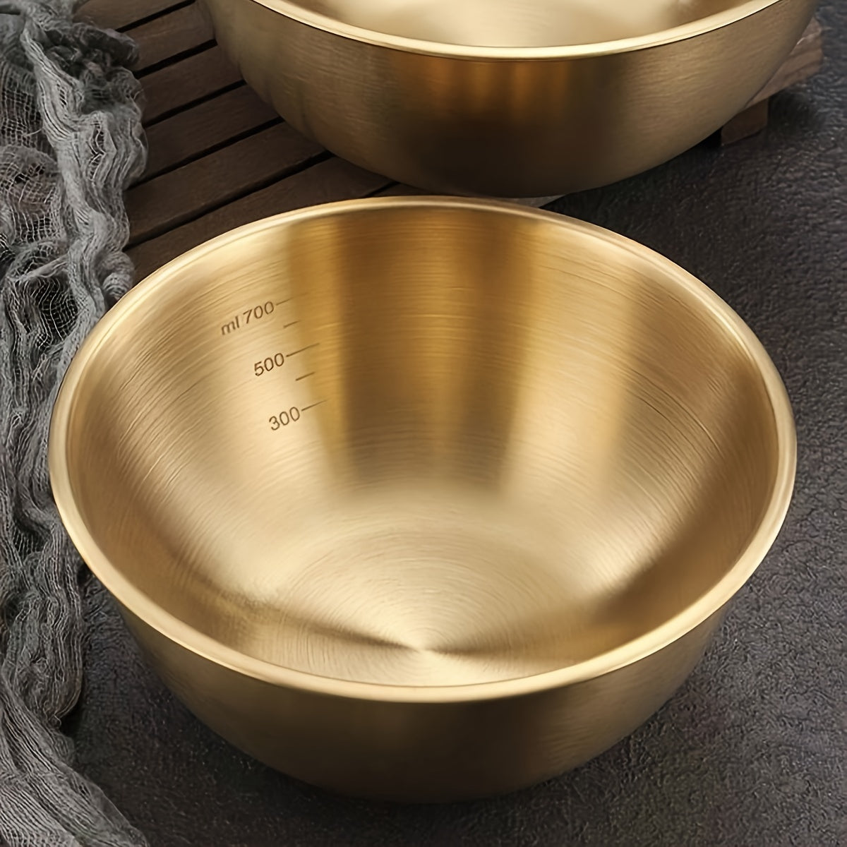 A durable stainless steel salad bowl with scale, oven safe and with brushed metal finish, suitable for home and school use.