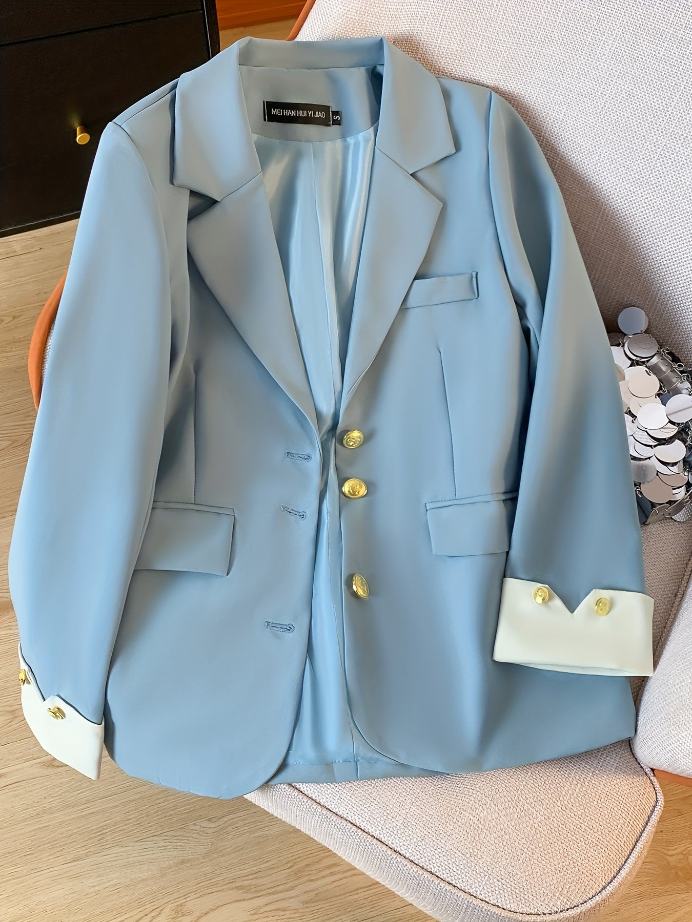 Stylish light blue blazer with golden button details for women, ideal for work in spring and fall.