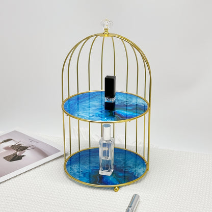 Elegant golden and white marble birdcage-inspired 2-tier makeup organizer with stainless steel rack and electrostatic spray finish. Portable and freestanding for bathroom and bedroom decor.