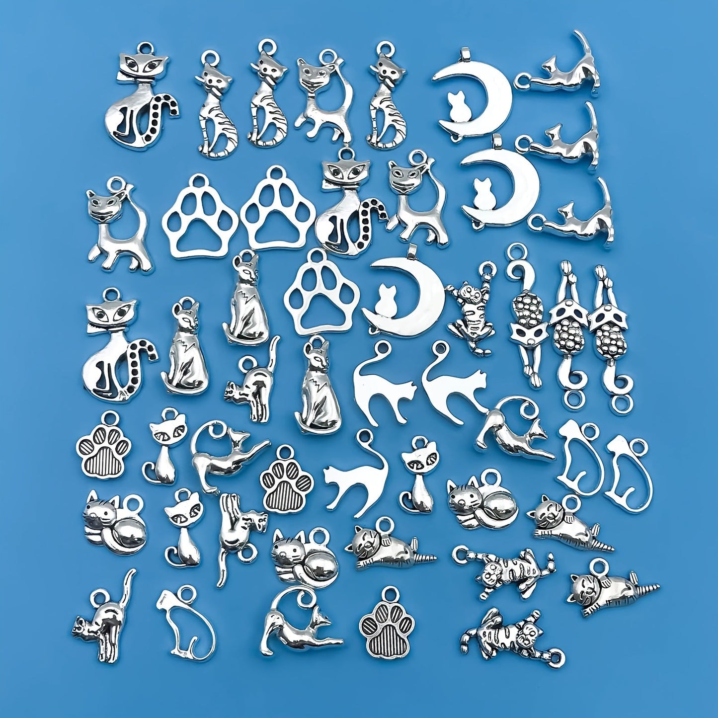 Create your own unique jewelry pieces with this set of 51 zinc alloy antique silvery animal series cat-shaped charms pendants. Perfect for DIY necklaces, bracelets, and earrings.