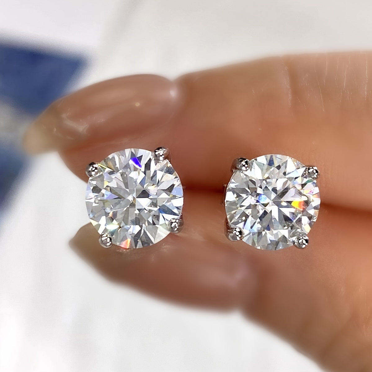 These elegant moissanite earrings come in a pair with a simple four-prong design weighing 1.2 grams for 0.5 carats, 1.7 grams for 1 carat, and 2.5 grams for 2 carats. Perfect for daily wear, these exquisite high-end ladies' jewelry pieces make a stunning