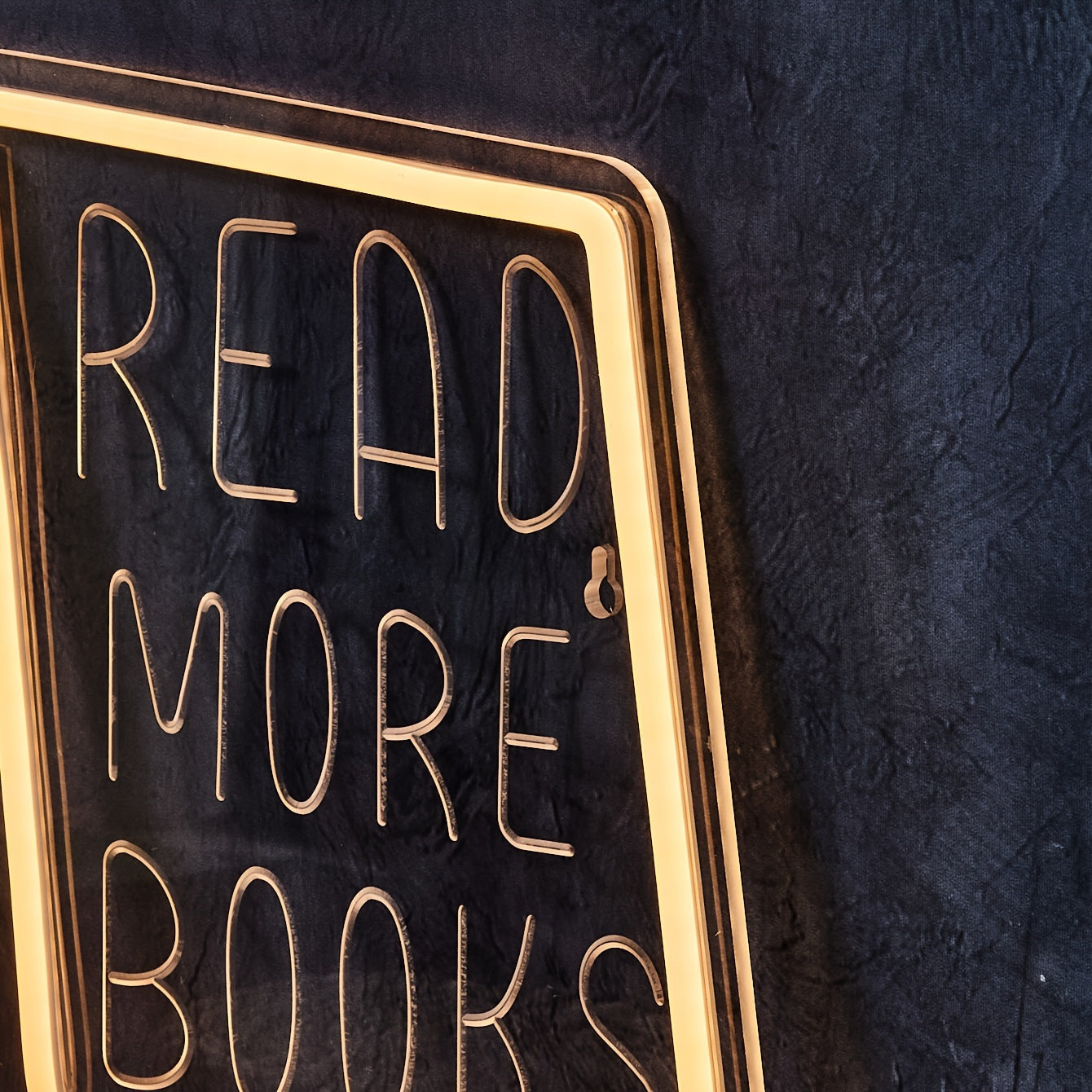 Neon "READ MORE BOOKS" sign for book lovers, perfect for home or office décor. Ideal for girls' bedroom and study area. USB-powered and wall-mounted.