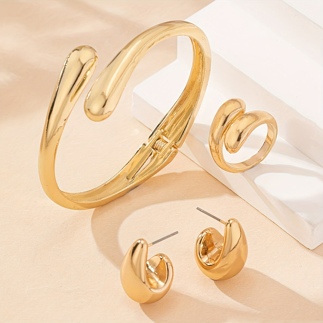 A set of women's jewelry, including earrings, a ring, and a bracelet with a spring design, ideal for everyday elegance.