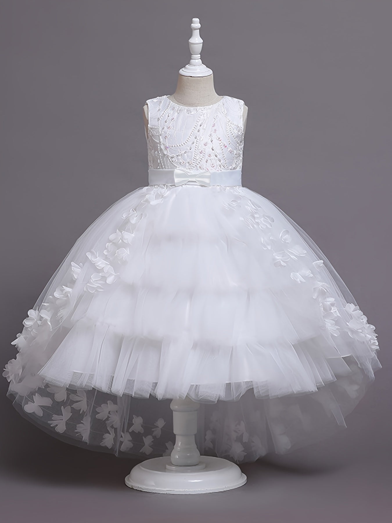 Elegant sleeveless princess dress with flowing tail, lace, and floral embellishments. Perfect for pageants, weddings, piano performances, and birthday parties. Made with tweedlike texture