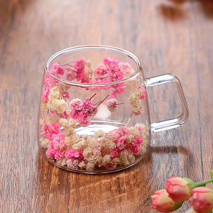 Elegant floral glass coffee mug with real dried flowers, double-walled insulated design in pink and clear. Hand wash only, BPA-free. Perfect for tea or coffee at home.