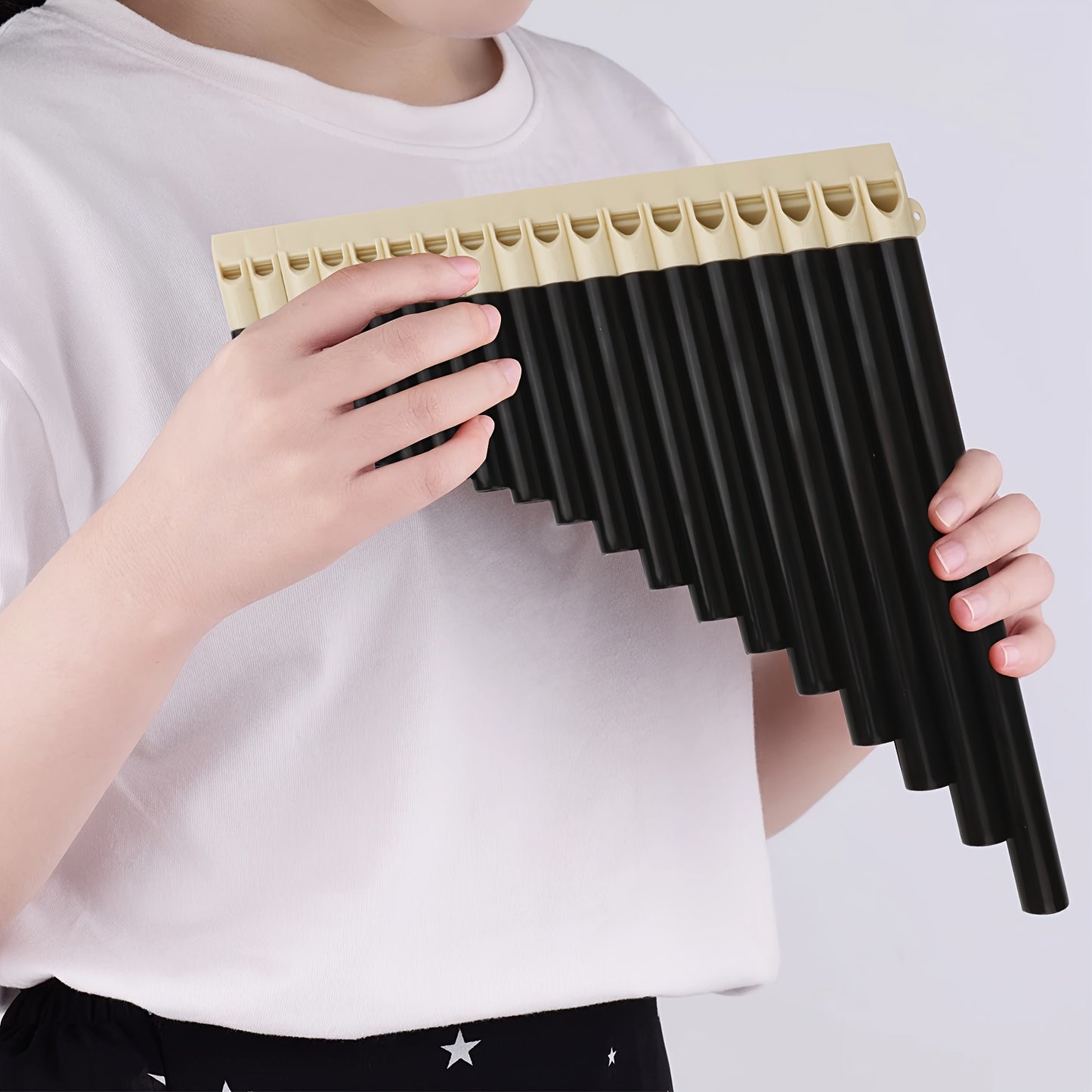 Black ABS pan flute with 18 tubes, classic style, includes carrying bag. Easy to play, portable, comfortable grip, smooth mouthpiece. Ideal for performance, teaching, and practice.