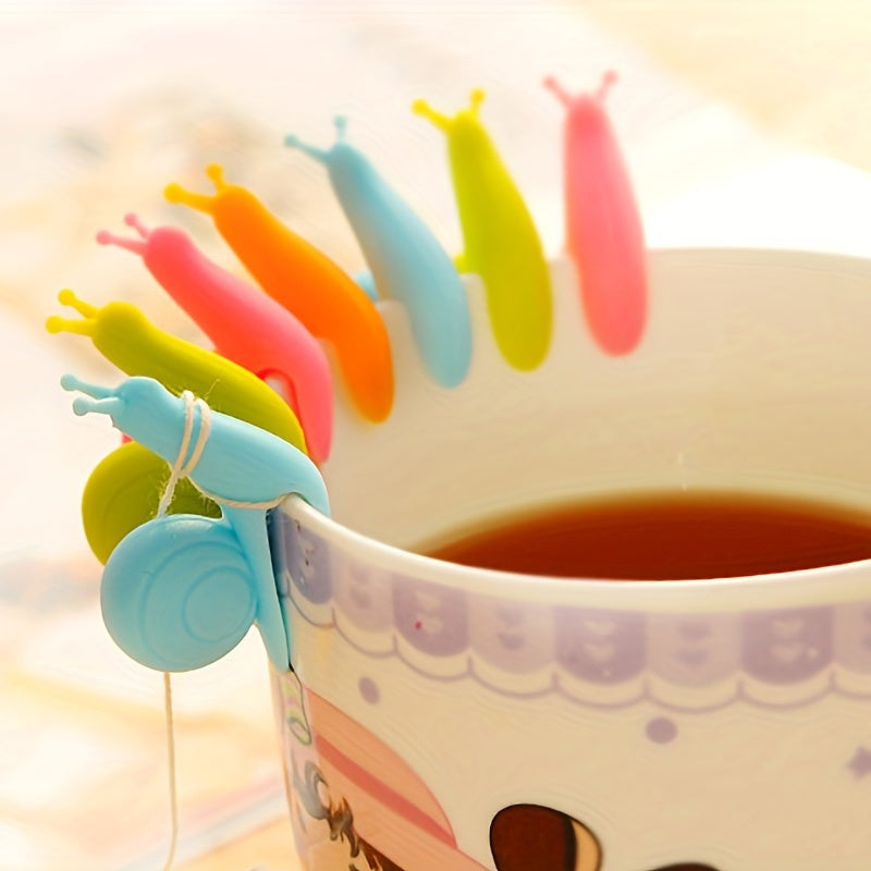 A collection of 8 silicone tea bags designed in the shape of adorable snails, along with macaron tea cups, hangers for tea bags, unique snail-shaped tea bag strings, racks for tea bags, and identifiers for cups. These silicone kitchen gadgets are ideal