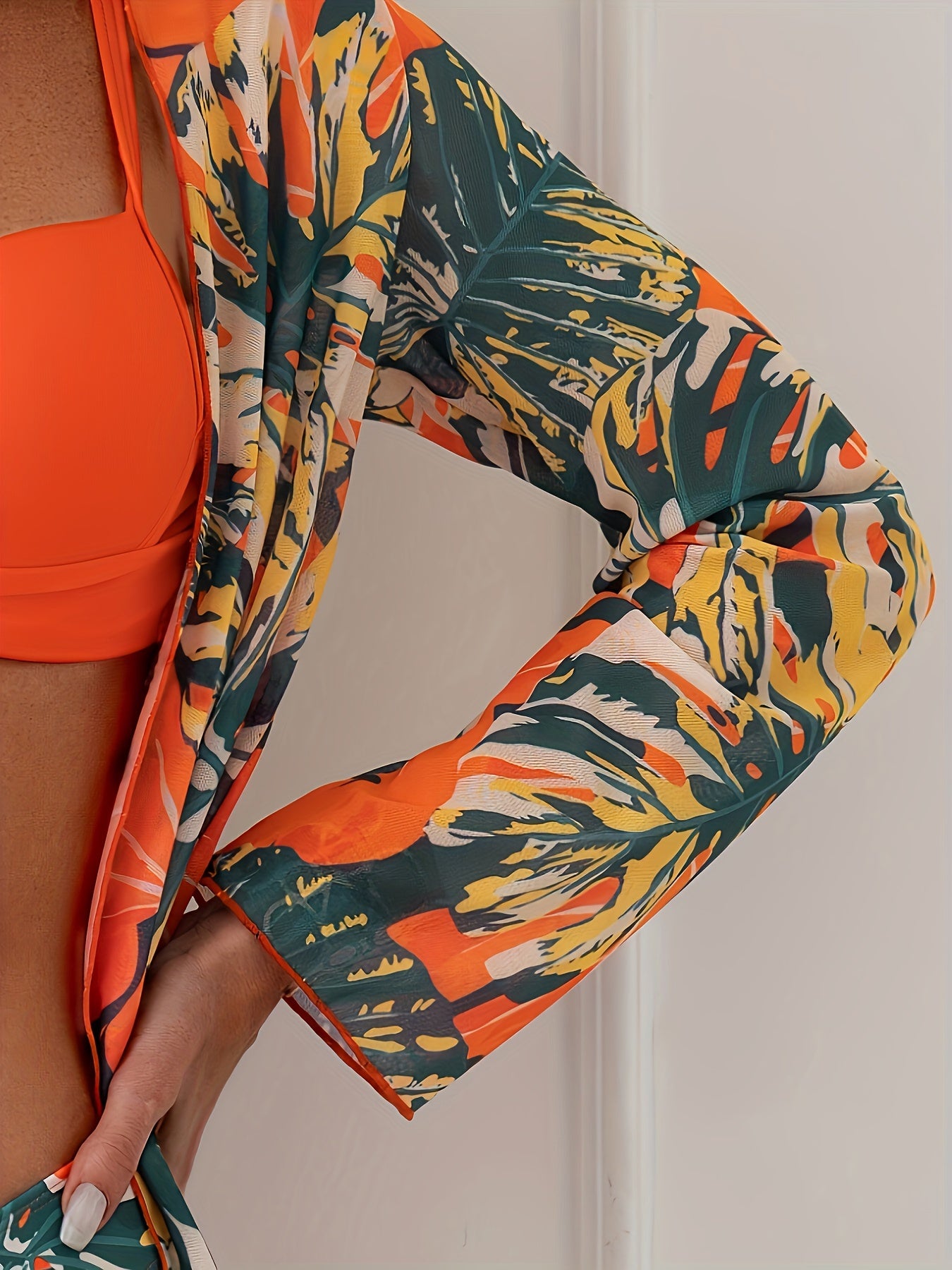 Vibrant summer beachwear set includes tropical print swimsuit with long sleeve kimono cover-up, high-waisted bottoms, and spaghetti strap top made of polyester blend.