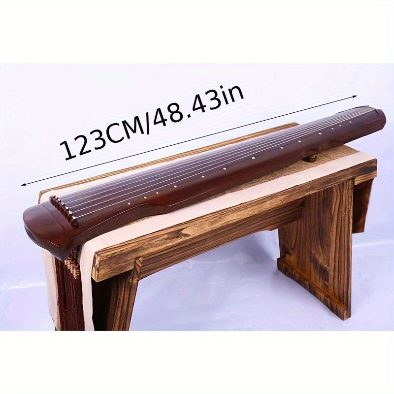 NUNUGGS Traditional Chinese Guqin made of solid paulownia wood with elegant black finish and golden tone tuning pins. Suitable for beginners, photo props, and antique interpretation.