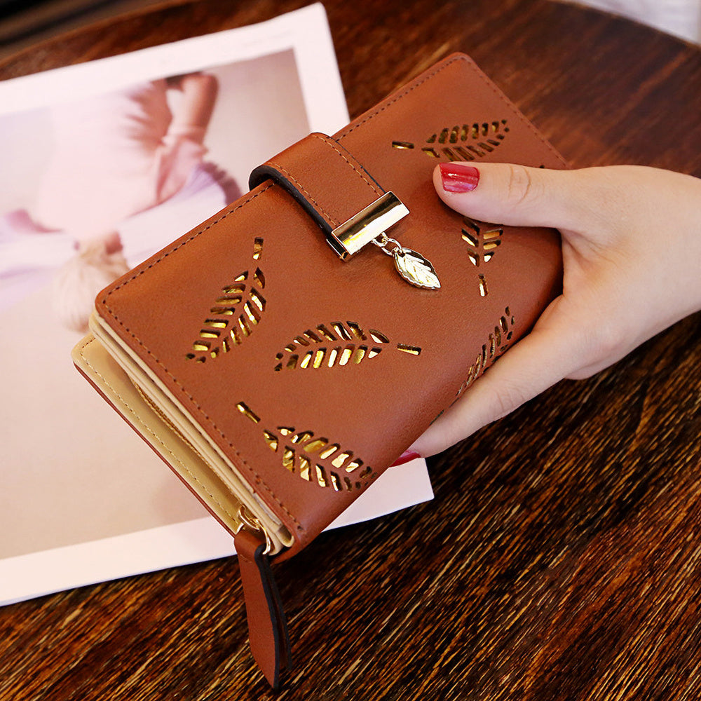 Black synthetic leather women's wallet with golden leaf design, featuring card holders, coin pouch, and snap closure.