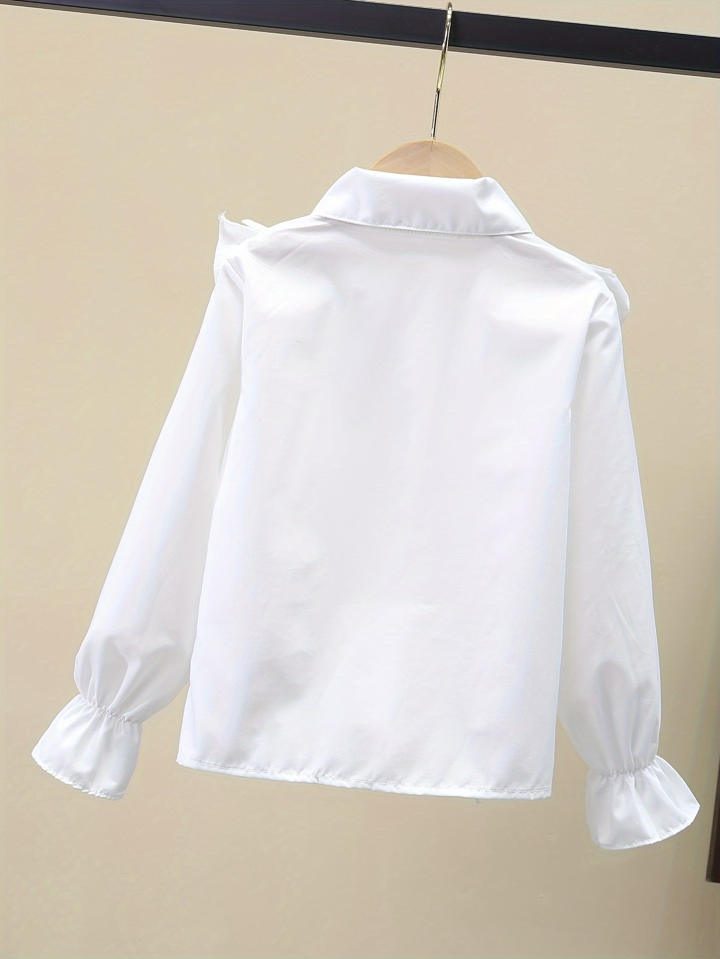 Stylish girls' long-sleeve dress shirt with ruffled cuffs and metal buttons - perfect for school uniforms or fashionable looks.