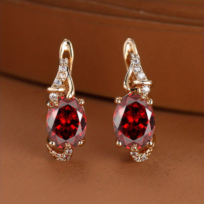 Trendy women's earrings featuring blue, white, red, and pink stones in round and oval cuts. These anniversary claw earrings are plated with 18K gold. Perfect for adding a pop of color to any outfit.