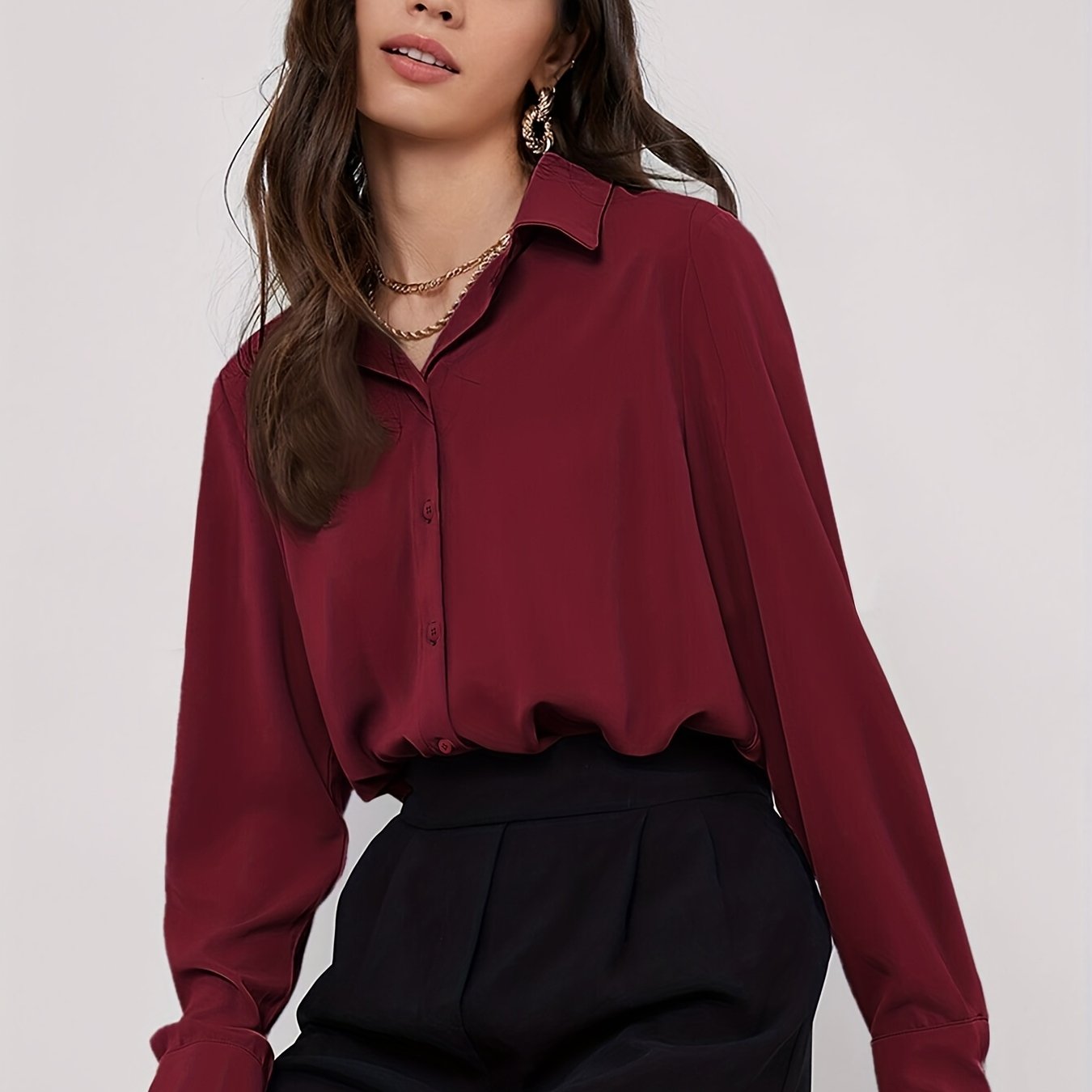 Stylish maroon button-up blouse for women, with long sleeves, curved hem, and made of machine-washable polyester blend. Perfect for work or casual wear.