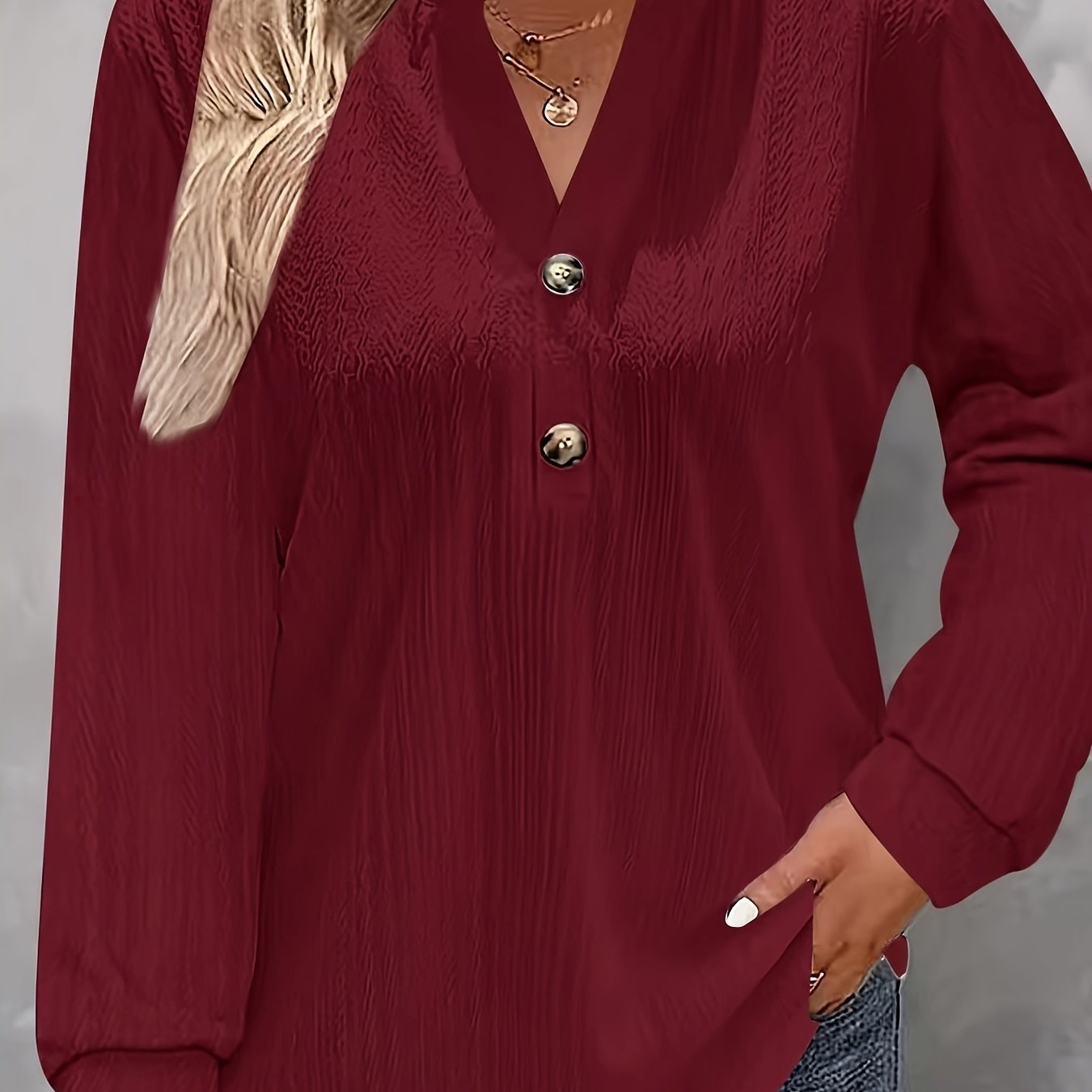 Light pink V-neck shirt with long sleeves and button detail, perfect for fall/winter in soft polyester blend.