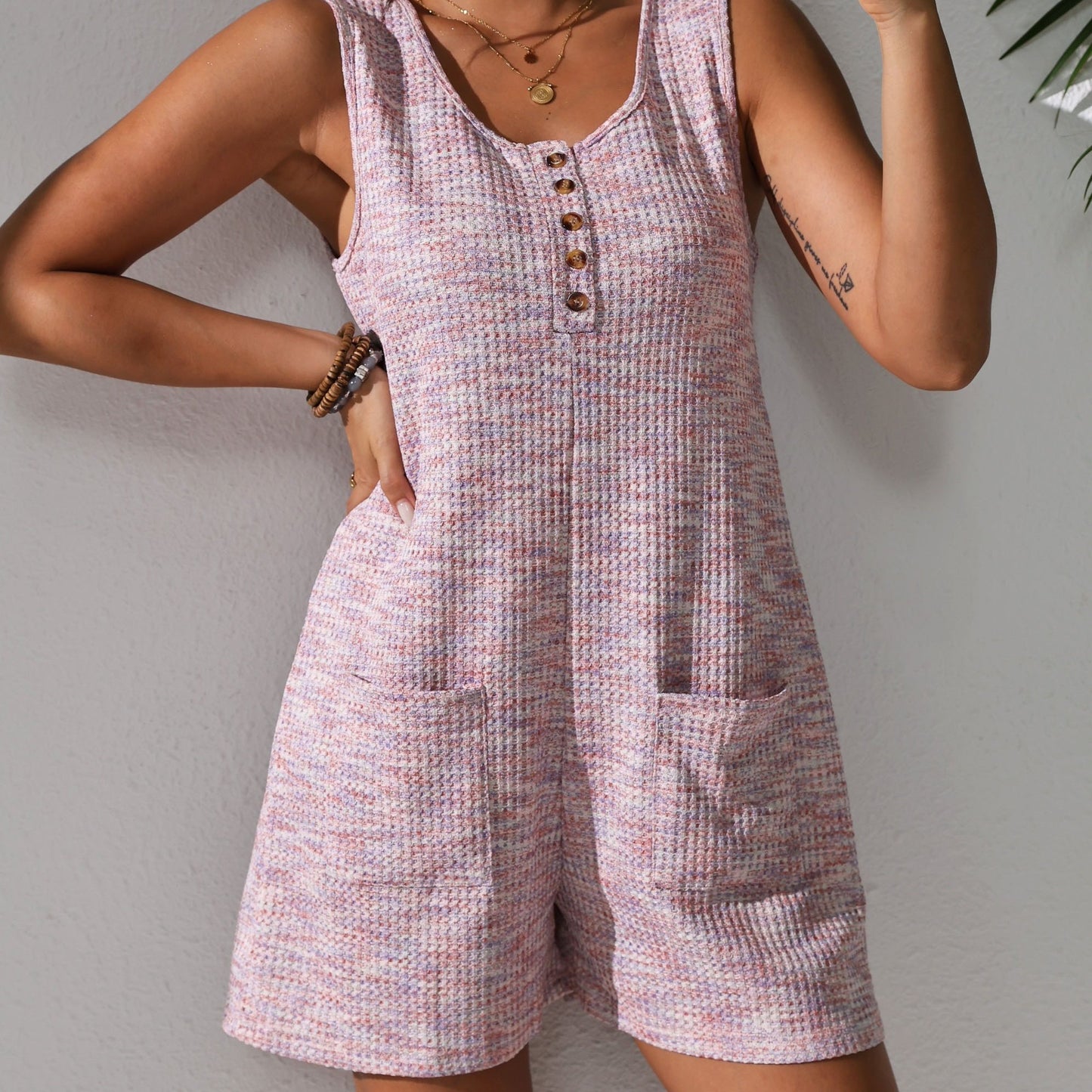 Sleeveless waffle knit romper with pockets for plus-size women in pastel pink. Comfortable and stretchy, perfect for spring/summer.