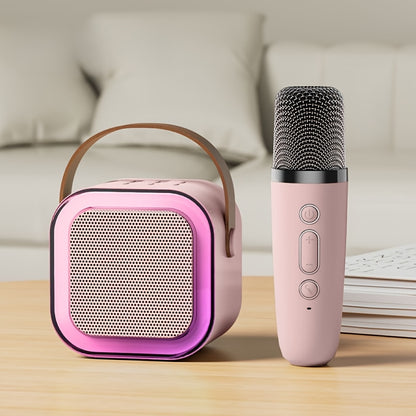 Portable karaoke speaker with light, handheld microphone included. USB rechargeable, ideal for home, car, camping, and parties. Pink/black color.