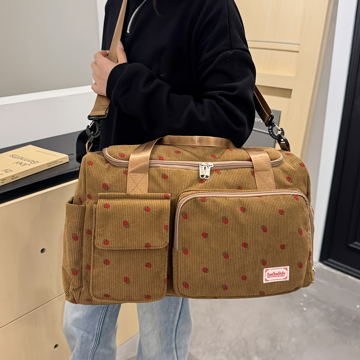 A spacious corduroy travel bag with strawberry print, wet and dry separation, shoe compartment, perfect for vacations, outings, school, crossbody use, and gym.