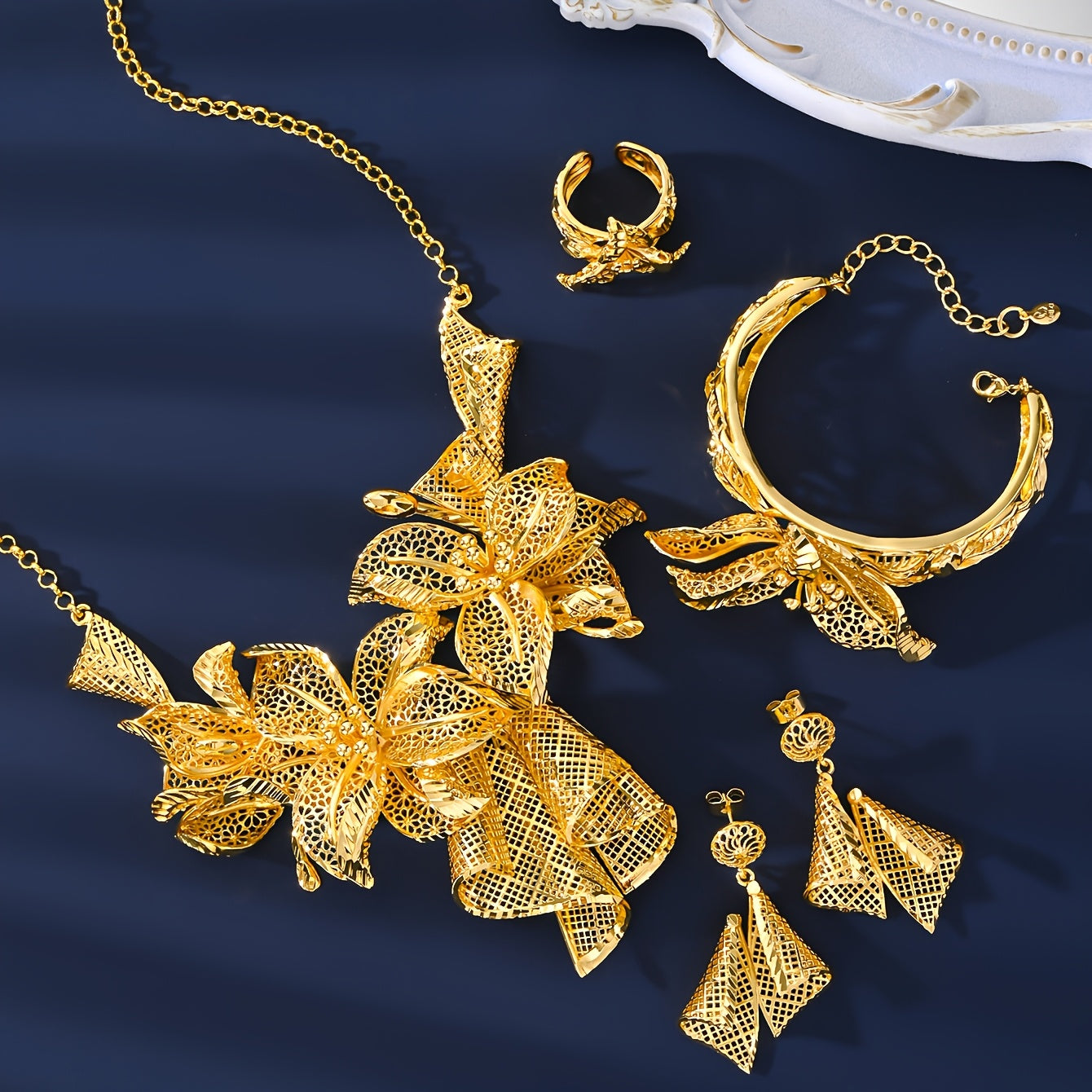 A luxurious jewelry set plated with 18K gold, showcasing a stunning floral necklace, a versatile adjustable ring, and charming pendant earrings - ideal for both everyday wear and special occasions.