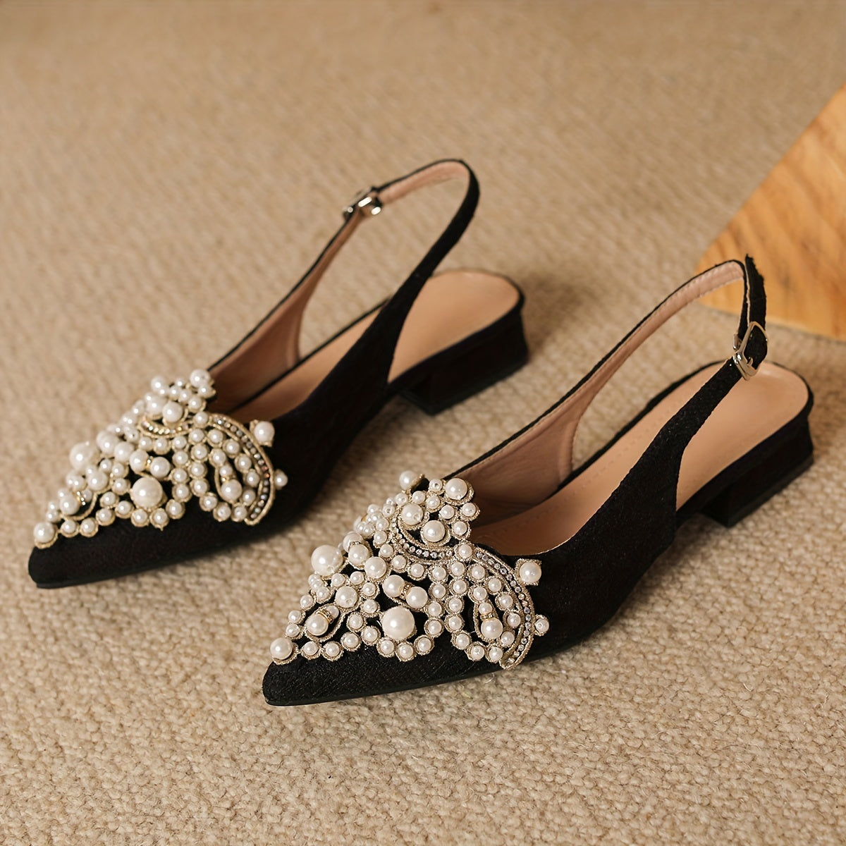 Women's low heel shoes with faux pearl decoration, point toe design, and buckle strap.