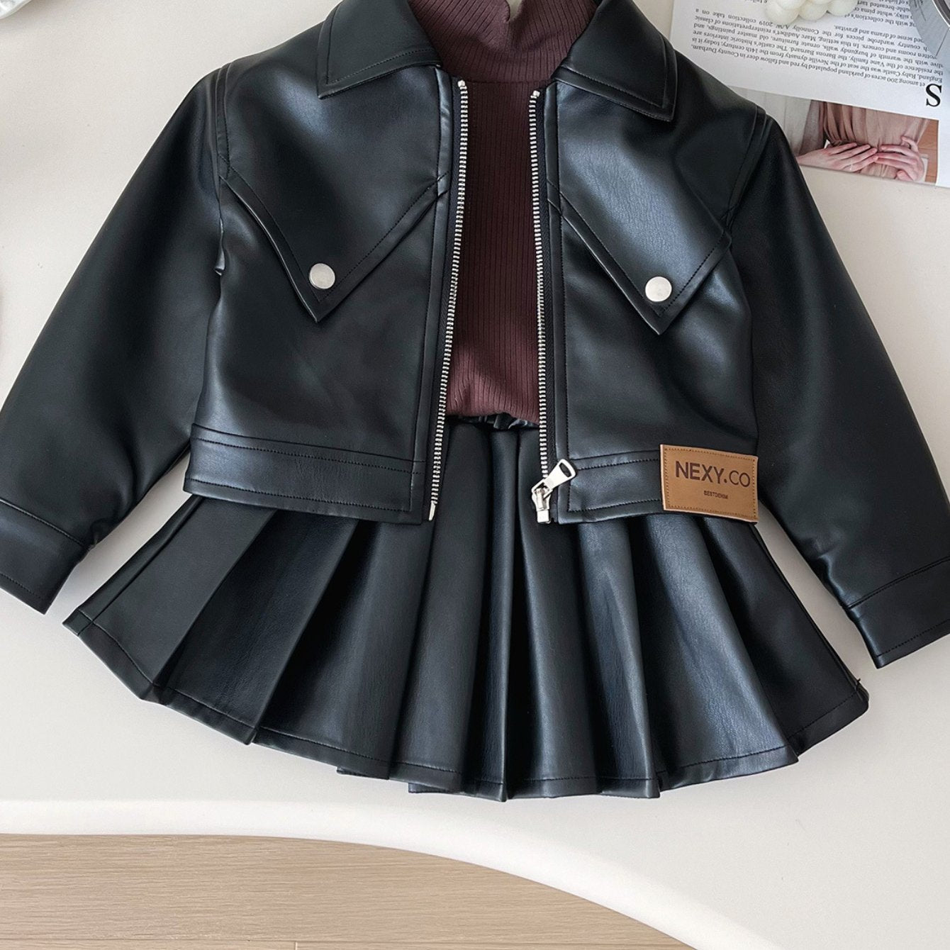 Kids' set with faux leather jacket and pleated skirt, peplum top in solid color, ideal for spring/fall. Made of 73% polyurethane, 24% polyester, and 3% non-stretch woven fabric.