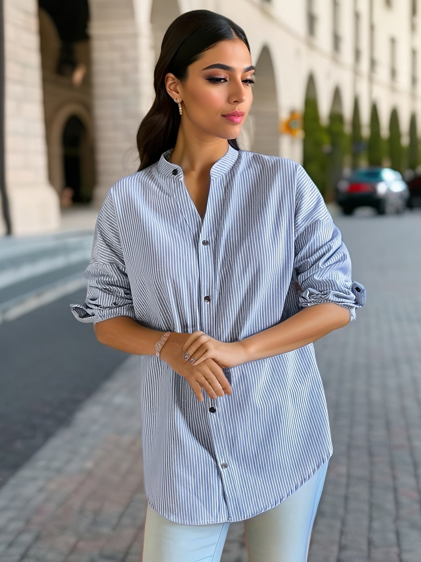 Women's striped shirt with drop shoulders, long sleeves, v-neck, and button closure.