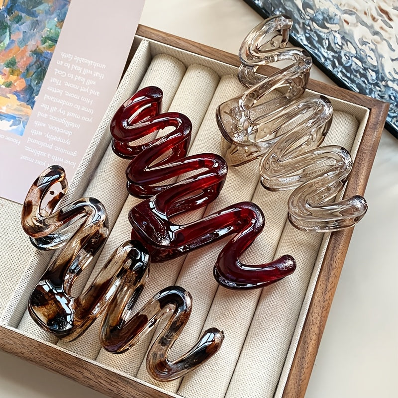 3 Wavy Leopard Print Hair Claw Clips in Clear, Red, and Brown. Stylish plastic accessories for everyday and gifting.