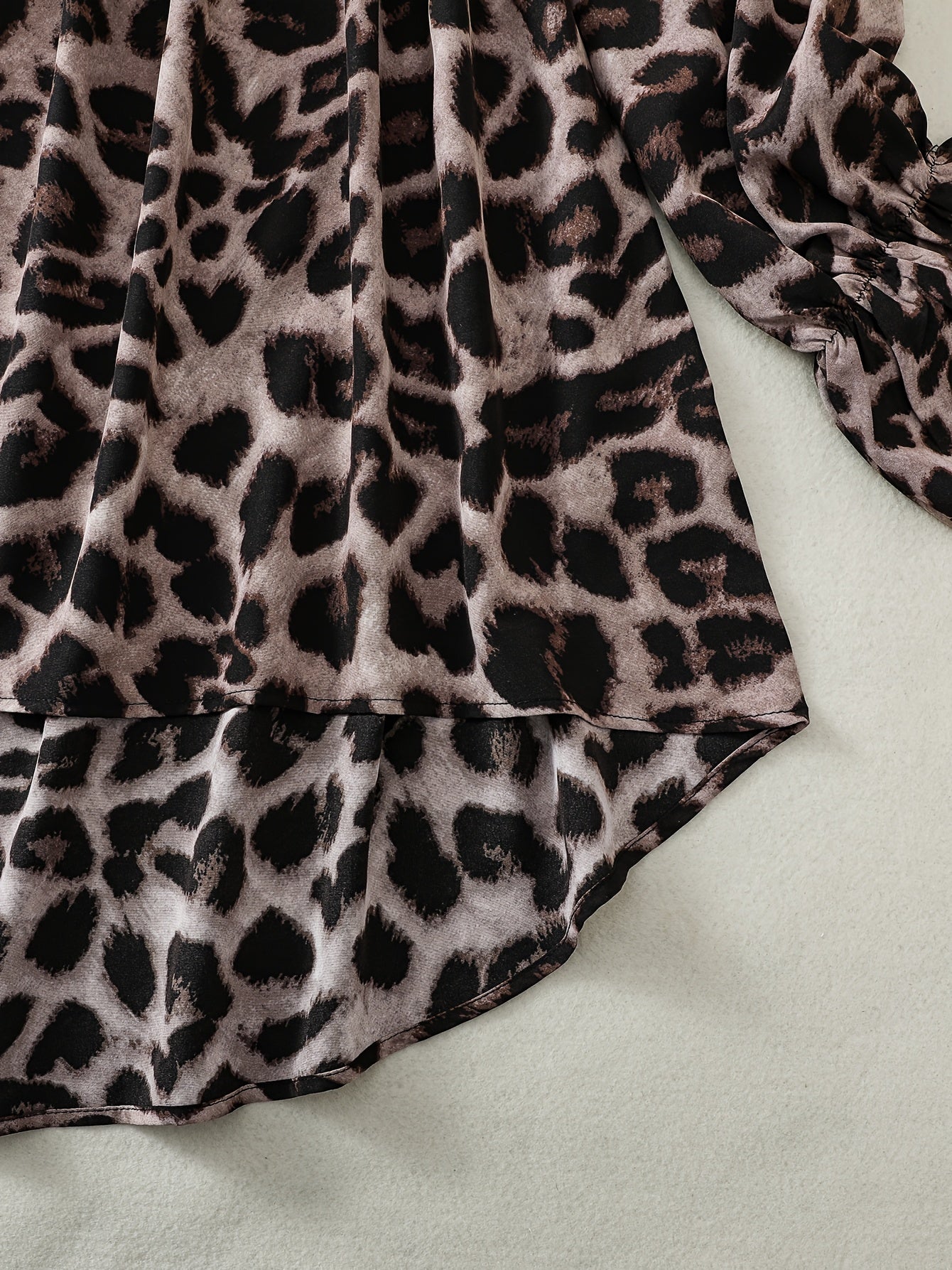 Stylish leopard print off-shoulder blouse with asymmetrical hem in non-stretch polyester blend for women.