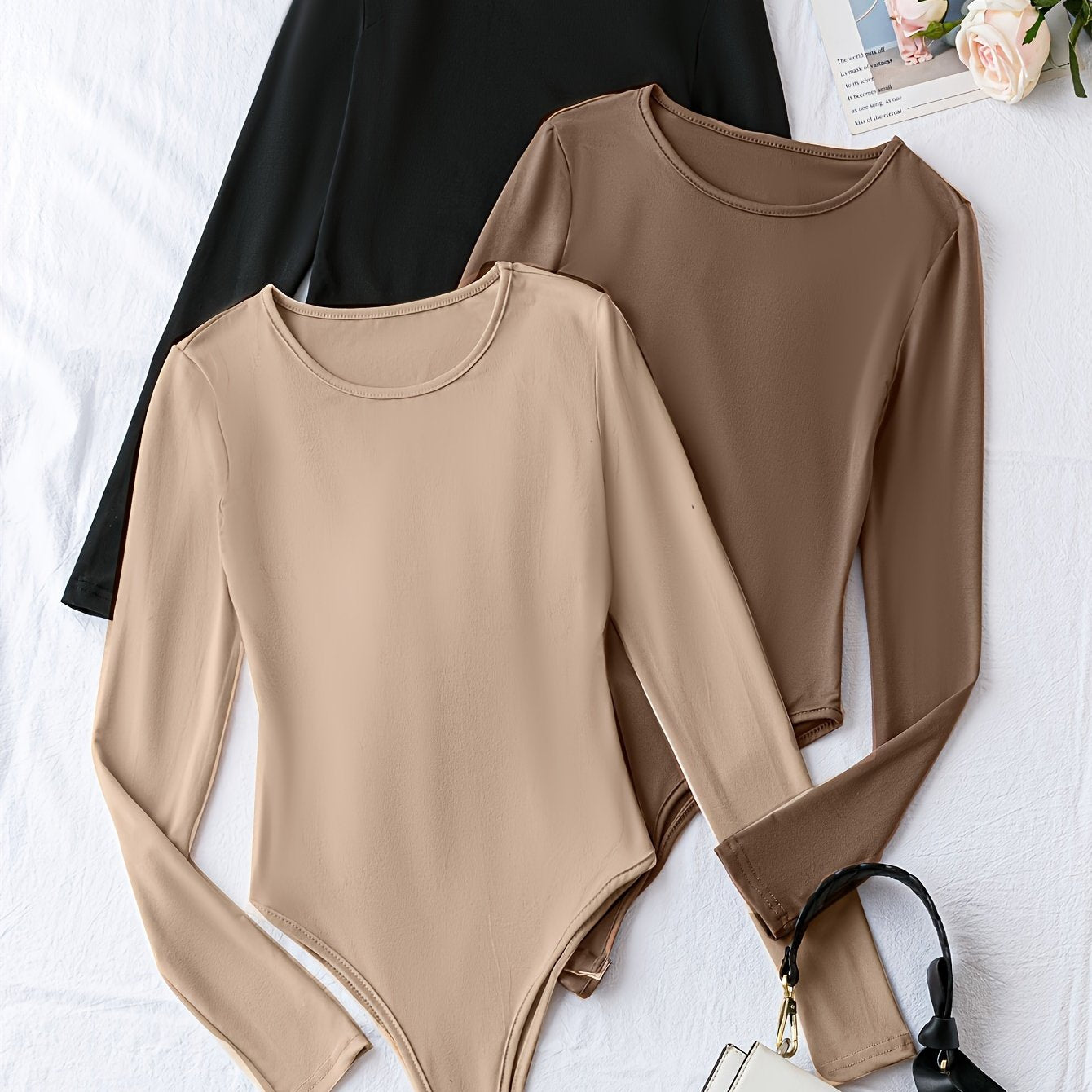 Pack of three solid crew neck long sleeve bodysuits for women. Casual one-piece clothing.