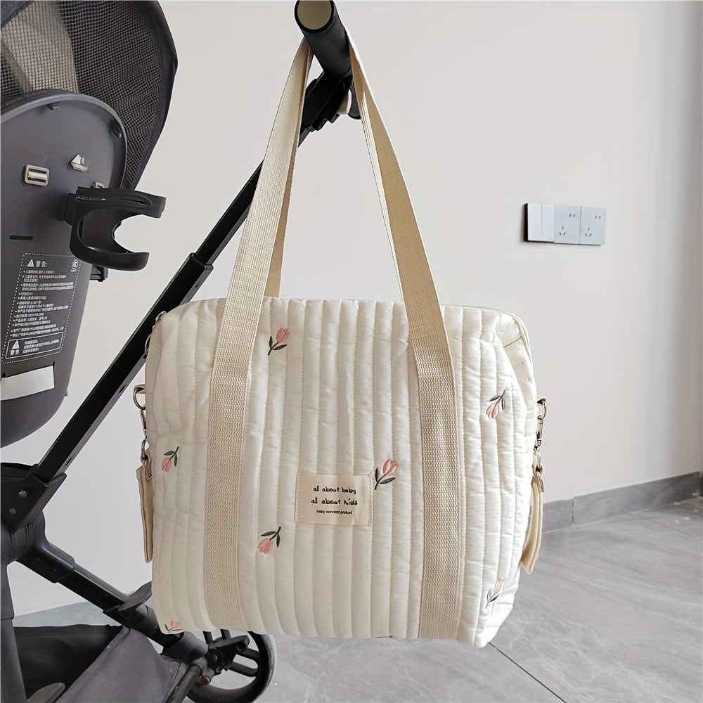 Cotton embroidered and quilted mommy handbag with trolley and hanging feature. Includes diaper bag, bottle finishing bag, and multifunctional mother bag. Zipper style closure. Measures 36x30x12CM.