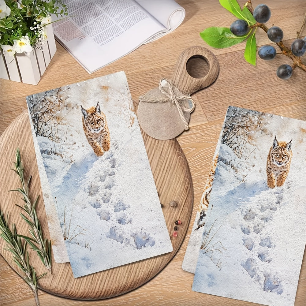 Two pieces of Lynx Snow Footprints kitchen towels, made of super absorbent polyester knit fabric. These towels are machine washable and feature a contemporary coastal style, measuring 40.64x60.96 cm. They are perfect as dish hand towels for holiday decor.