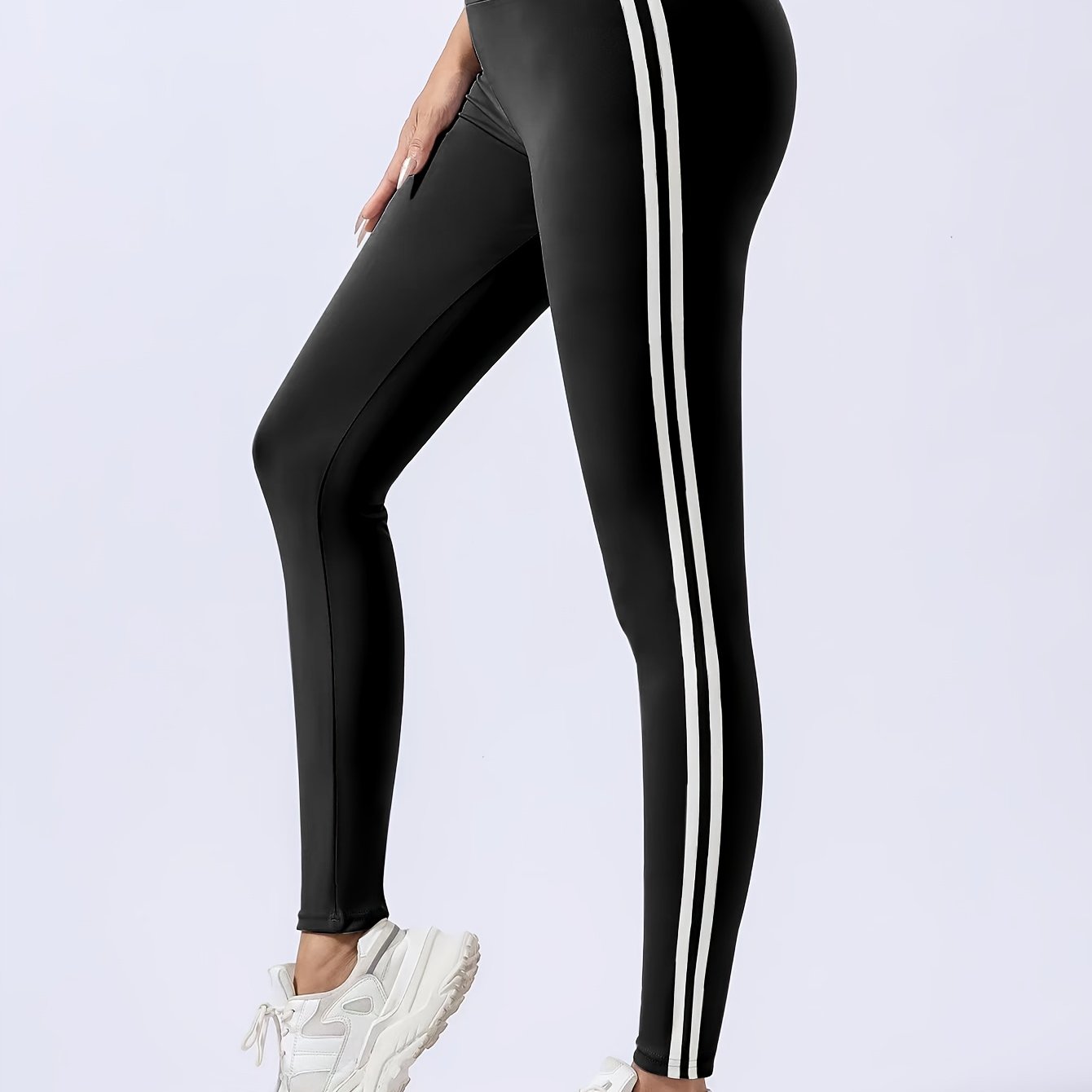 Women's chic black leggings with white side stripes, high-waist design, butt lifting, and tummy control features. Made with quick-dry and breathable fabric for a slimming effect. Machine