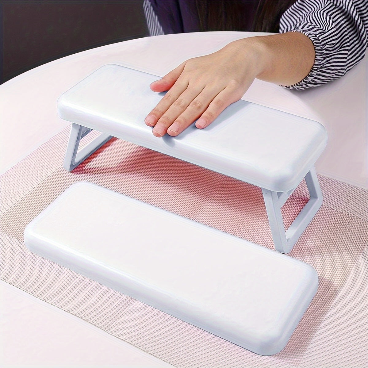 Single folding nail armrest for manicurists, with hand support and wrist rest for salon use.