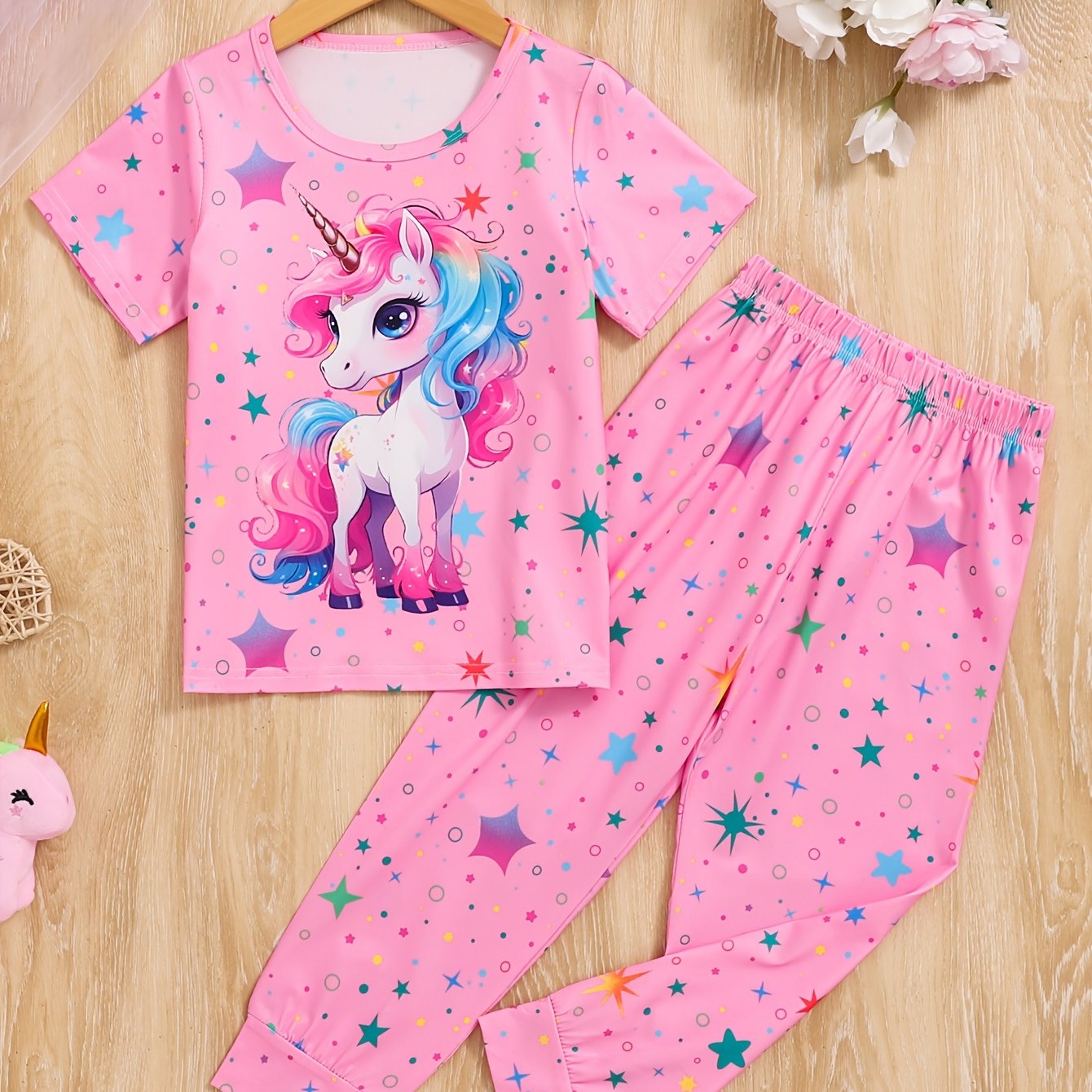 Pink unicorn and star pattern pajama set for girls, flame retardant, cozy short sleeve top and long pants, ideal spring/autumn gift, machine washable.