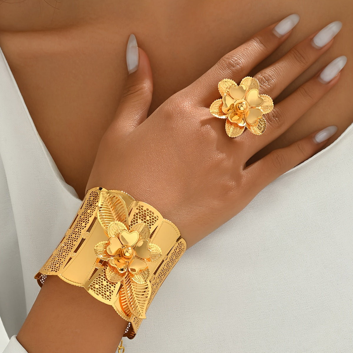 Indulge in luxury with this exquisite Women's Classic Hollow Floral Bracelet and Ring Set, perfect for both everyday wear and special occasions. This set includes a stunning 2-piece Arabic Wide Bracelet and Adjustable Ring Set, designed with intricate