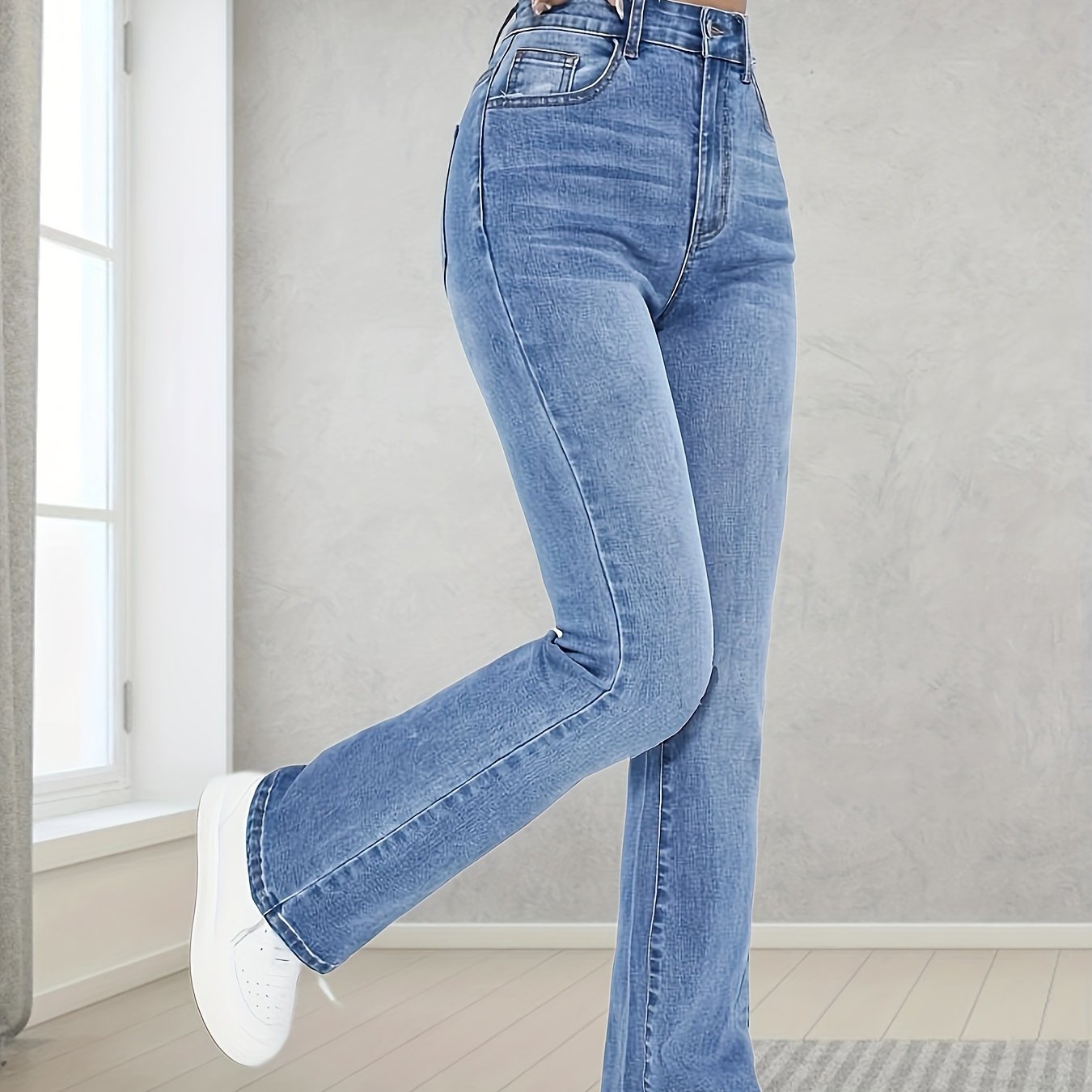 Washed blue flare leg jeans with stretch, slant pockets, and bell bottom design for women.