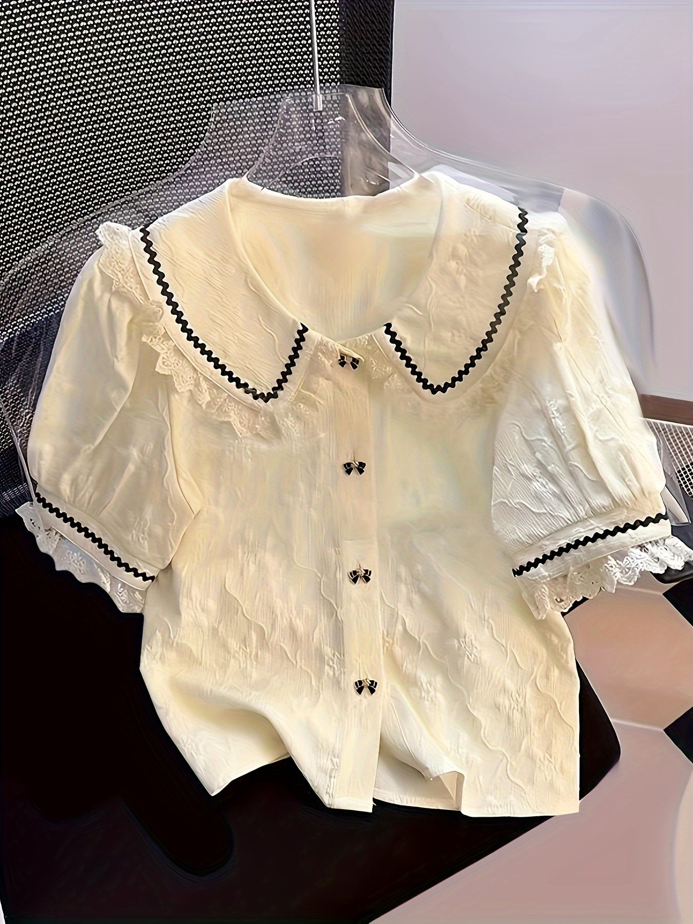 Polyester floral lace shirt with short sleeves, ruffle neckline, and lapel collar. Perfect for spring/summer in a young style with 120g/m² fabric weight.