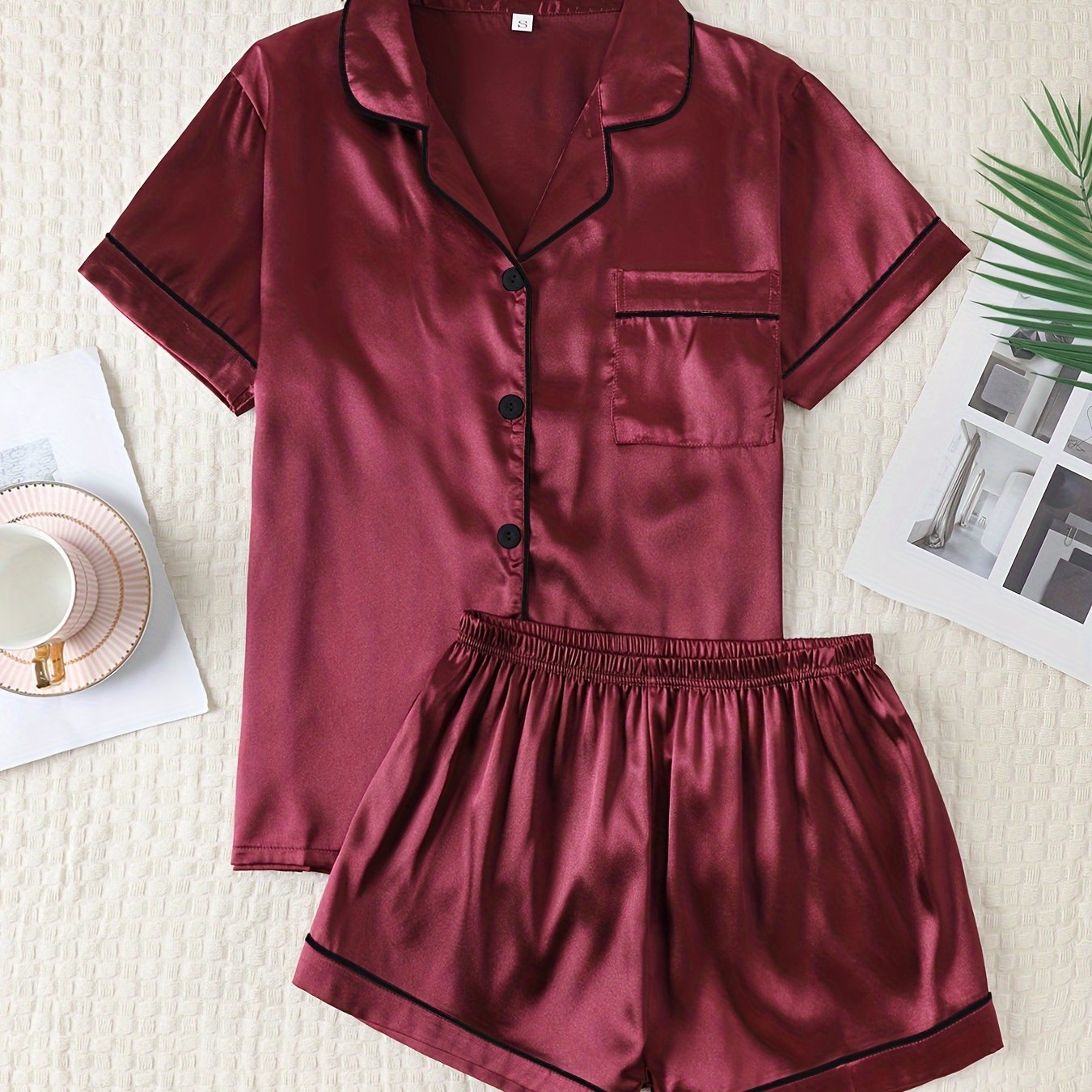 Satin lounge set includes a short sleeve button-up top with lapel collar and elastic shorts.