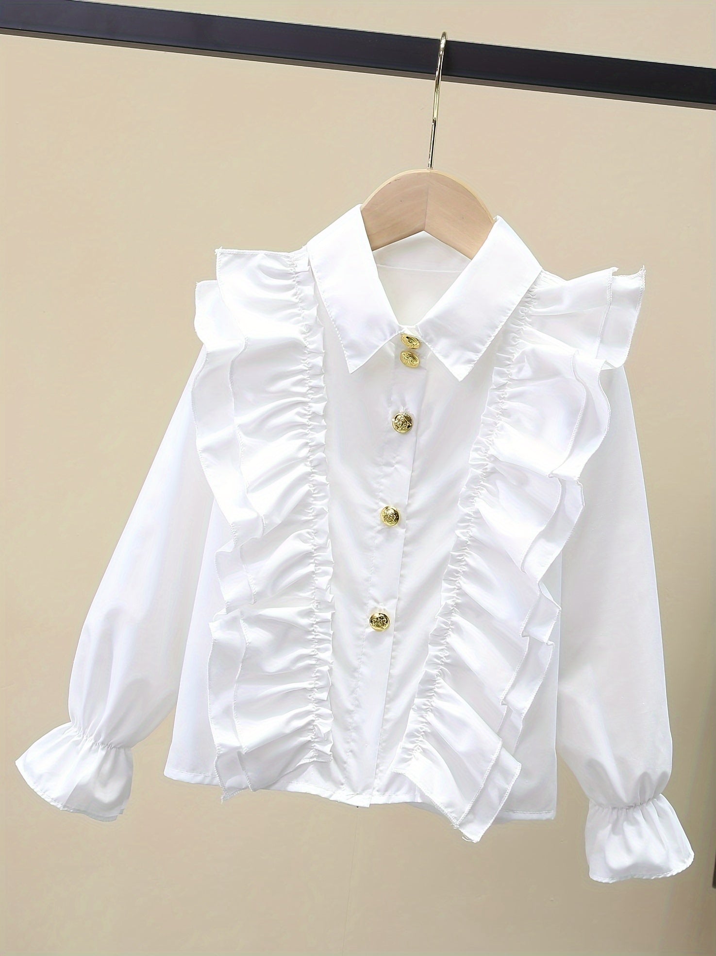 Stylish girls' long-sleeve dress shirt with ruffled cuffs and metal buttons - perfect for school uniforms or fashionable looks.