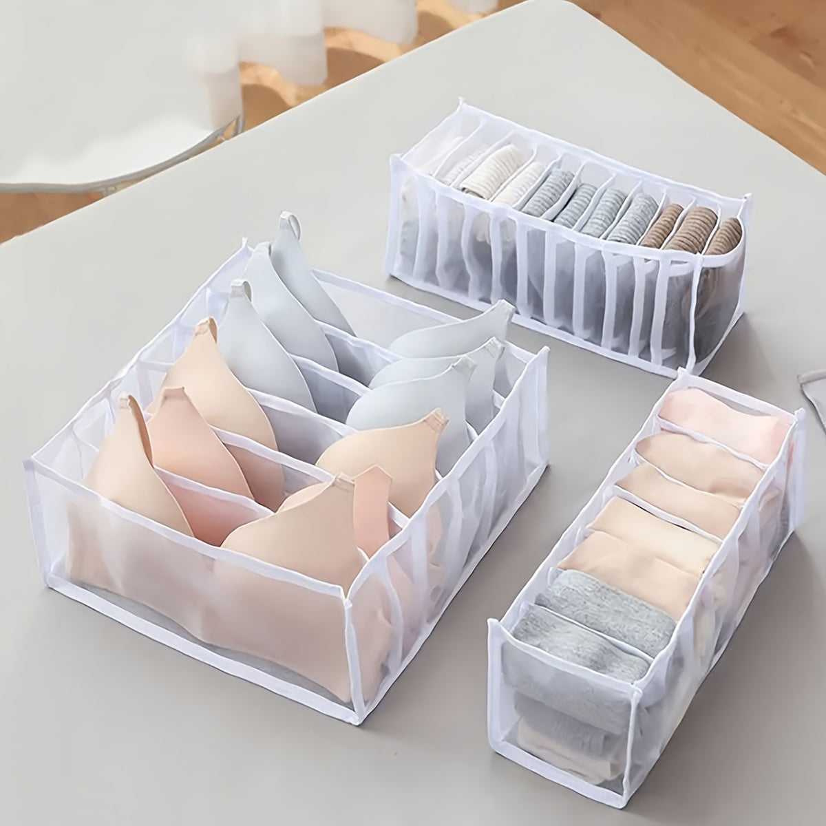 Set of three nylon mesh drawer organizers with 6, 7, and 11 grids. These foldable boxes are designed for storing underwear, socks, and bras. They feature a brushed finish and can be easily inserted into wardrobe closets to separate your items.