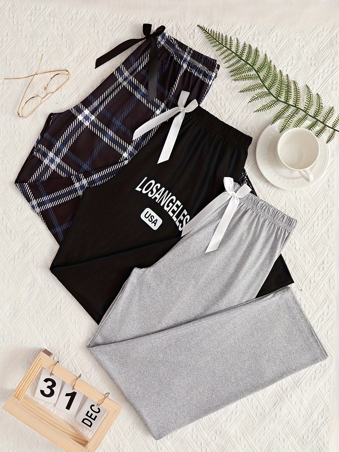 3 Women's lounge pants with plaid and "LOS ANGELES" print. Made of comfy polyester blend with elastic waist and bow detail. Suitable for all-season sleepwear and casual wear.