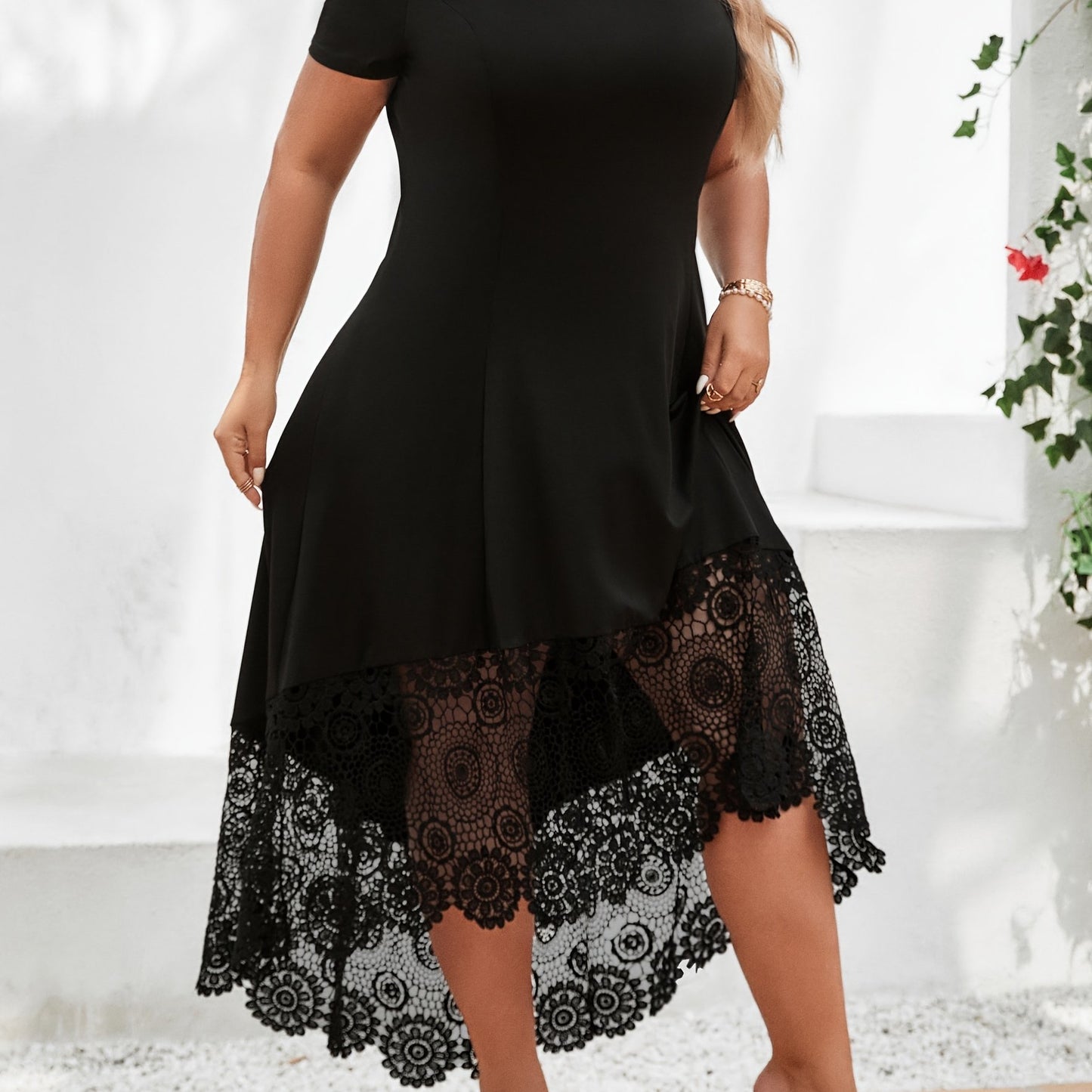 Stylish plus size black dress with white lace panel features off-shoulder design, short sleeves, and asymmetrical hem. Made of medium stretch, machine washable fabric, this dress is ideal